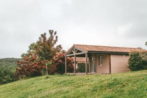 een klein huis op een heuvel in een veld bij Terres de France - Les Hameaux des Lacs in Monclar-de-Quercy