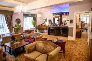 a living room with couches and tables and a kitchen at Langtry Manor Hotel in Bournemouth