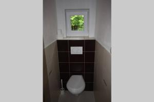 uma pequena casa de banho com um WC e uma janela em Chata na Jankuli em Staré Hamry
