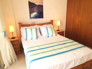 a bedroom with a large bed with two lamps at Ground floor One Bedroom Apartment, Vanessa Complex in Peyia