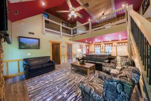 a large living room with couches and a staircase at Lap of Luxury chalet in Gatlinburg