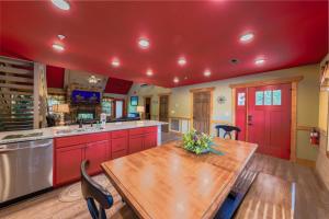 a kitchen with red cabinets and a wooden table at Lap of Luxury chalet in Gatlinburg +73 photos