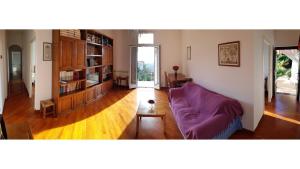 a living room with a purple couch and wooden floors at Casa Dalia in Pietrabruna