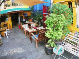 an outdoor patio with tables and chairs and plants at DDM House in Bangkok