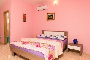 a bedroom with a bed and a pink wall at Lovely house in Rovinj