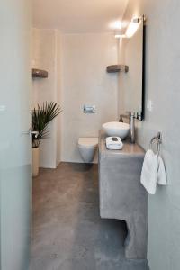 a bathroom with a sink and a toilet at Suites of the Gods Cave Spa Hotel in Megalokhori