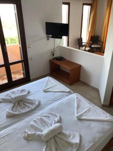 Televízia a/alebo spoločenská miestnosť v ubytovaní Kyma Hotel