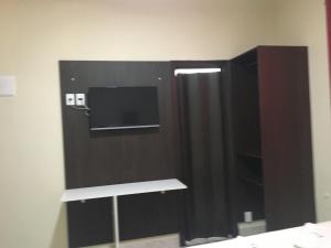 a black cabinet with a television in a room at Hotel Imperial Inn in São Caetano do Sul