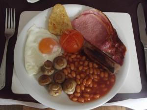 a plate of food with eggs bacon beans and meat at Tudor House in Great Yarmouth