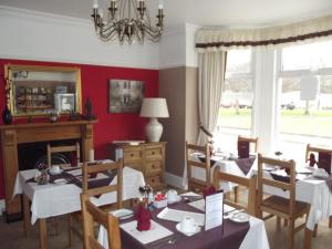 a dining room with tables and chairs and a mirror at Tudor House in Great Yarmouth