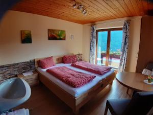 a bedroom with a bed and a tub and a sink at Himmenhof in Tux