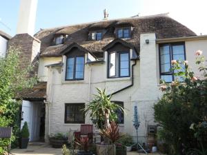 a large white house with a thatched roof at Myrtle Cottage B&B in Porlock