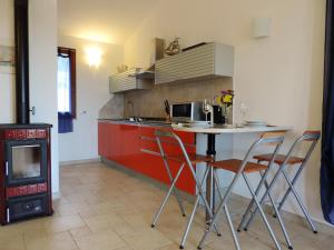 a kitchen with a table and chairs and a stove at La casetta celeste in Tertenìa