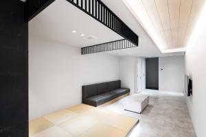 a living room with a couch and a skylight at SITSURAE OSAKA Hommachi/Shinsaibashi-Kita in Osaka