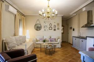 - un salon avec un canapé et un lustre dans l'établissement Apartamentos Baeza RN, à Baeza