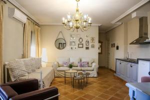 a living room with a couch and a chandelier at Apartamentos Baeza RN in Baeza