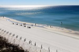 a group of people on a beach with the ocean at Wyndham Garden Fort Walton Beach Destin in Fort Walton Beach