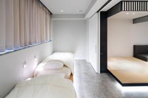 a bedroom with two beds and a window at SITSURAE OSAKA Hommachi/Shinsaibashi-Kita in Osaka
