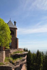 una iglesia en la cima de una colina con árboles en Hôtel-Restaurant Mont Sainte-Odile en Ottrott