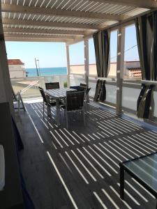 a deck with a table and chairs and the ocean at TERRAZZA SUL MARE in Punta Secca