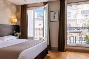Ένα ή περισσότερα κρεβάτια σε δωμάτιο στο Hôtel Volney Opéra