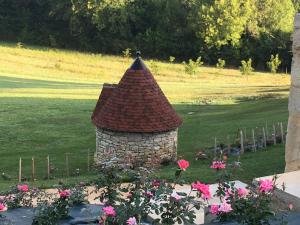 a stone tower in a garden with pink flowers at La Tour de Ginaillac in Les Arques +20 photos