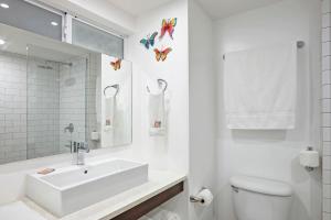 a white toilet sitting next to a bath tub in a bathroom at Butterfly Beach Hotel in Christ Church
