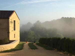 an old building on a road next to a field at La Tour de Ginaillac in Les Arques