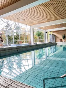 une grande piscine avec un grand plafond en verre dans l'établissement Hotelli Nuuksio, à Espoo