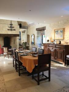 eine Küche und ein Esszimmer mit einem Tisch und Stühlen in der Unterkunft La Tour de Ginaillac in Les Arques