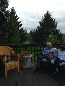 un hombre mayor y una mujer sentadas en un porche en Derinda House, en Elizabeth