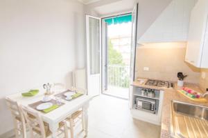 una cucina bianca con tavolo e piano cottura di Cittadella Apartment a Firenze