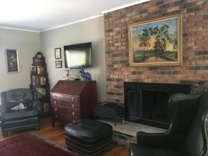 a living room with a brick fireplace and chairs at Derinda House in Elizabeth