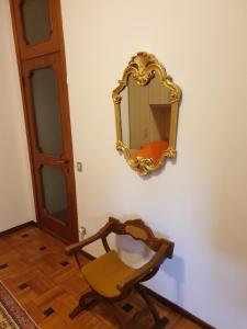 un espejo en una pared junto a una silla en Tranquillità e cordialità a 30 minuti da MIlano, en Busto Arsizio