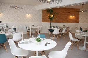 Hôtel Aux Vendanges de Bourgogne في باراي-لو-مونيال: مطعم بطاولات بيضاء وكراسي بيضاء