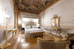 a bedroom with a bed and a mirror and chairs at Ca' Bonfadini Historic Experience in Venice