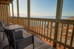 a porch with a table and chairs and the ocean at Icefiord Apartments in Ilulissat