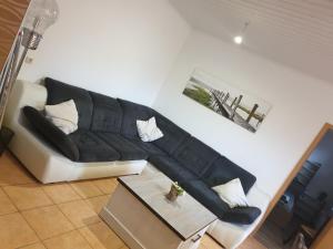 a living room with a black and white couch at Sunnesching 2 in Sankt Michaelisdonn