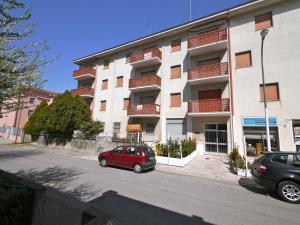 een rode auto geparkeerd voor een gebouw bij Appartamenti Vittoria in Lido di Pomposa