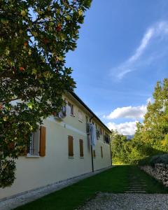 ボルソ・デル・グラッパにあるBeeHouse - La Casa delle Api Agriturismoの白い庭と木々の建物