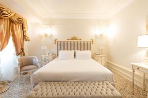 a bedroom with a large white bed and a chair at Ca' Bonfadini Historic Experience in Venice
