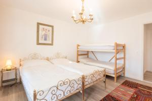 um quarto com uma cama, uma cadeira e um lustre em LAAX Homes - Casa Coray em Laax