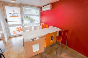a room with a table and chairs and a red wall at Premiere Classe Saint Quentin in Saint-Quentin