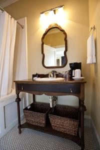 Dickson Street Inn في فايتيفيل: حمام مع حوض ومرآة