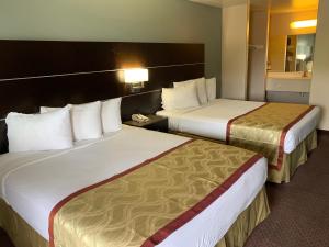 Tempat tidur dalam kamar di Olive Tree Inn & Suites