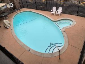 an overhead view of a swimming pool with two chairs at Olive Tree Inn & Suites in San Luis Obispo