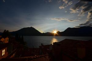 una puesta de sol sobre un cuerpo de agua con montañas en Varennahouse, en Varenna