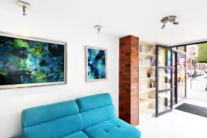 a living room with a blue couch and a book shelf at Centro 19 Hotel in Querétaro