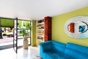 a living room with a blue couch and a mirror at Centro 19 Hotel in Querétaro +28 photos
