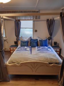 a bedroom with a canopy bed with blue pillows at Historisch übernachten Brinkerplatz 3 in Essen